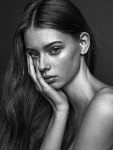 Black and white portrait photography reference photo of a young woman leaning on her hand